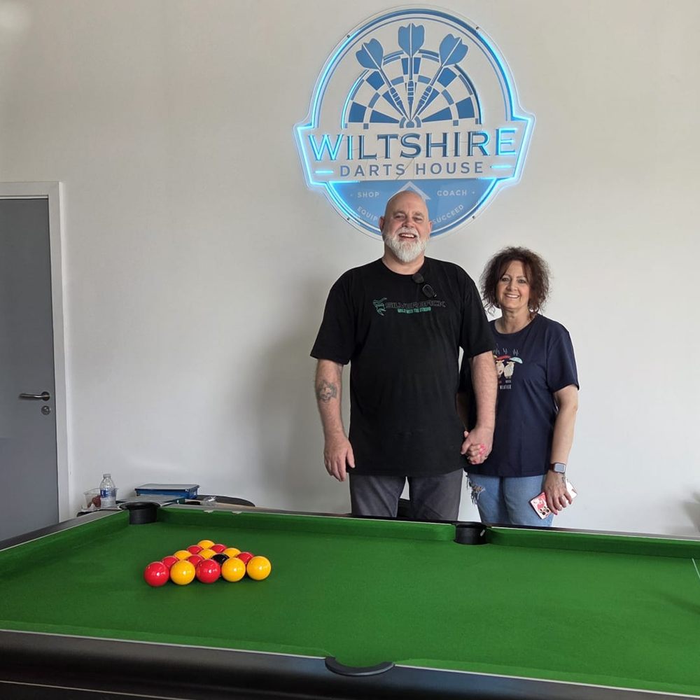 The 7ft pool table at Wiltshire Darts House, racked up under the neon venue sign